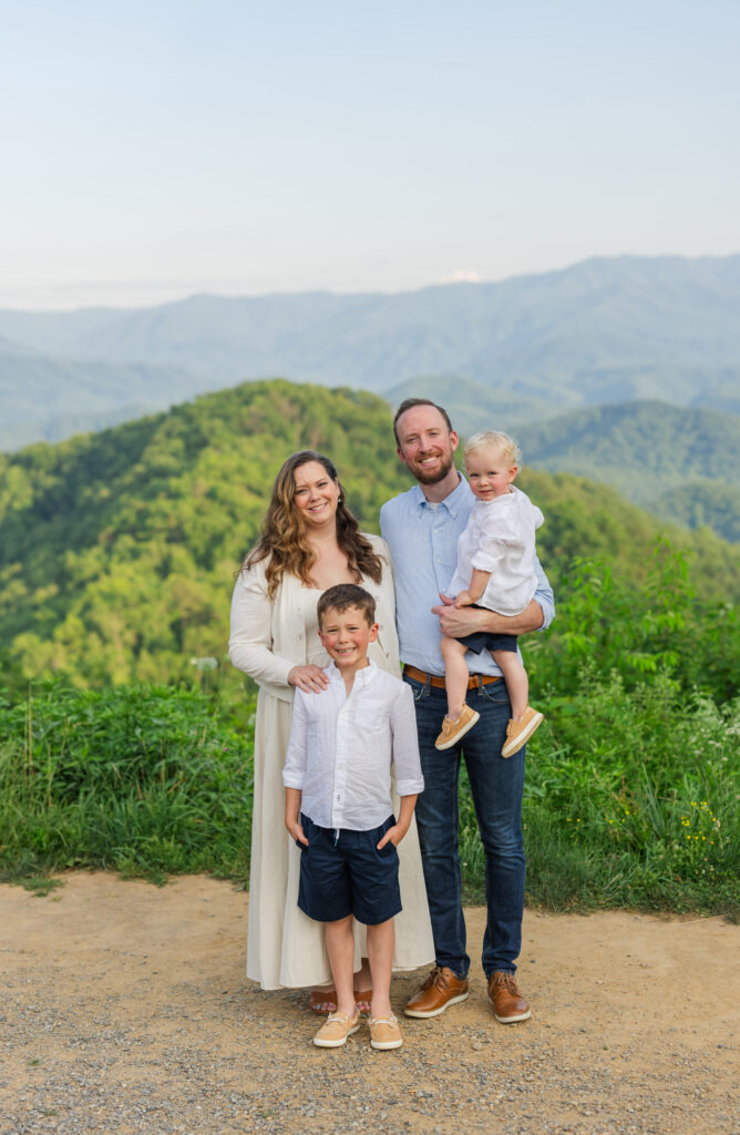 a smiling family having their portrait taken by a professional photographer in the smoky mountains in Gatlinburg, Tennessee