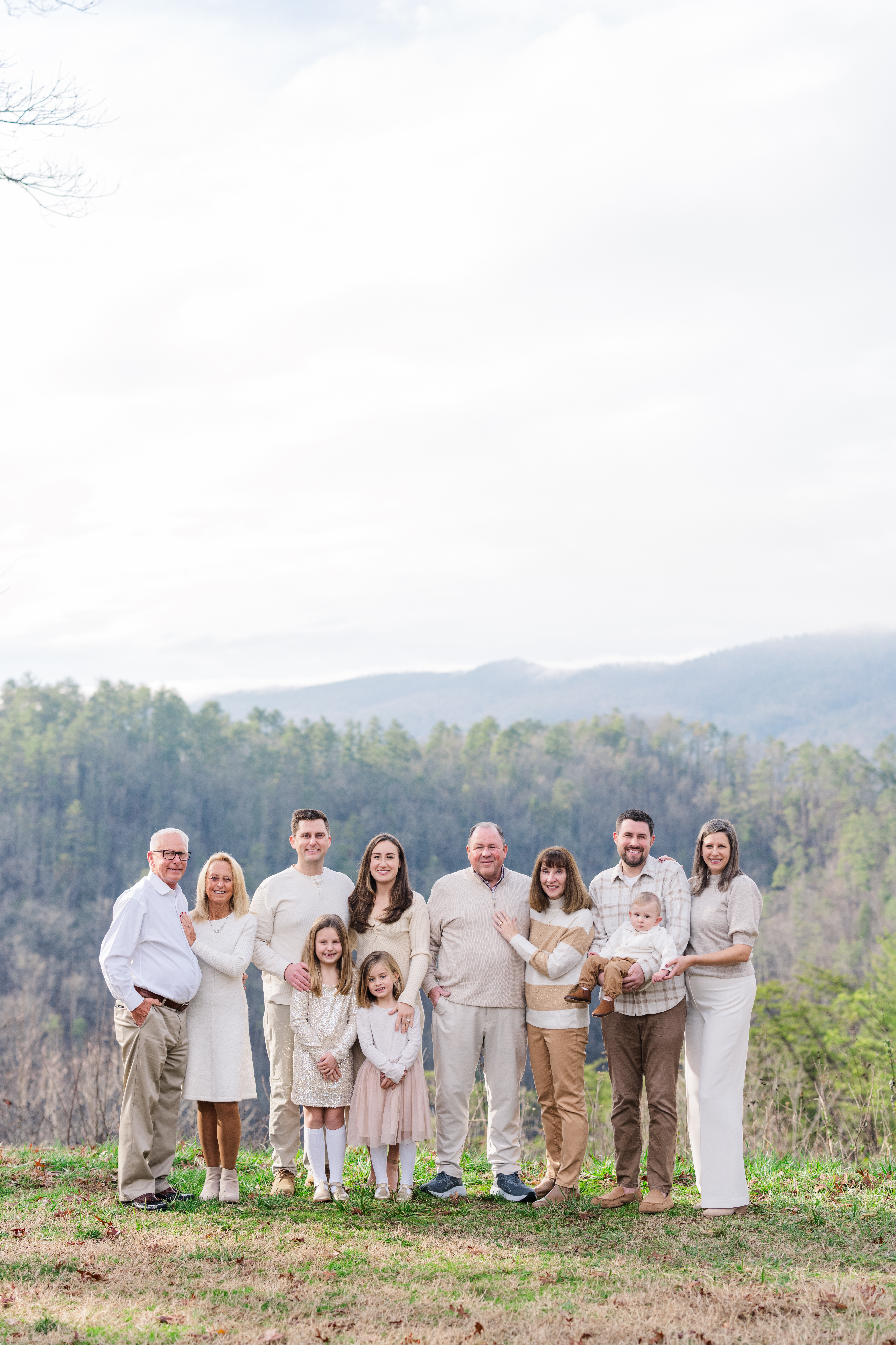 A gatlinburg photographer captures an extended family together smiling for the camera with the mountains in the background in the great smoky mountains national park