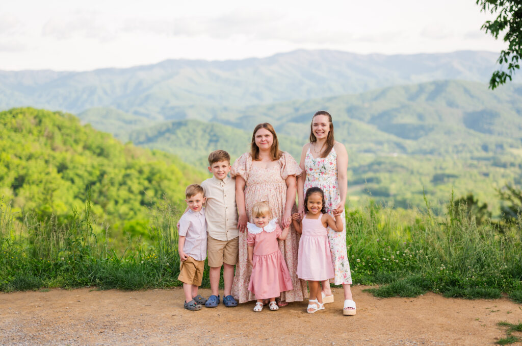 Candid Gatlinburg family photographer portrait of sisters and children overlooking the Smoky Mountains during vacation.