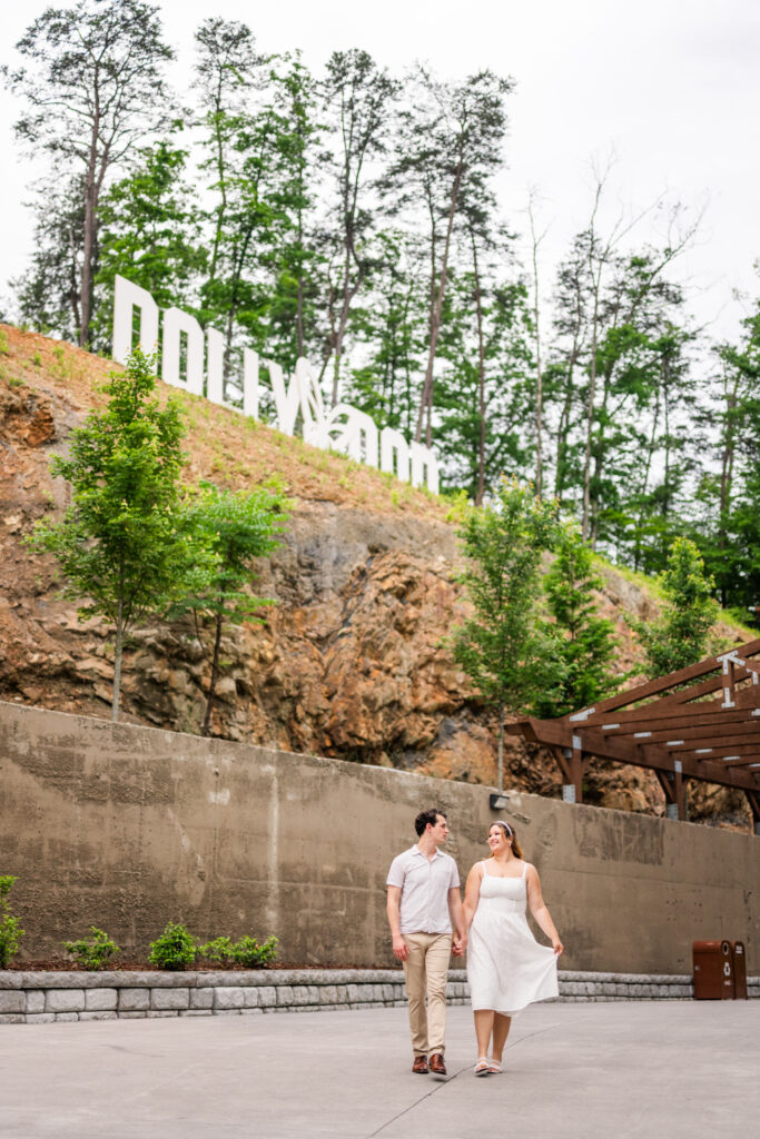 Dollywood engagement session in Pigeon Forge, Tennessee capturing couple holding hands and smiling at the camera