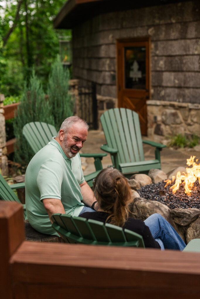 Photographer capturing intimate moment of couple after surprise proposal by the outdoor fire pit at The Greenbrier Restaurant in Gatlinburg, Tennessee, Smoky Mountains.
