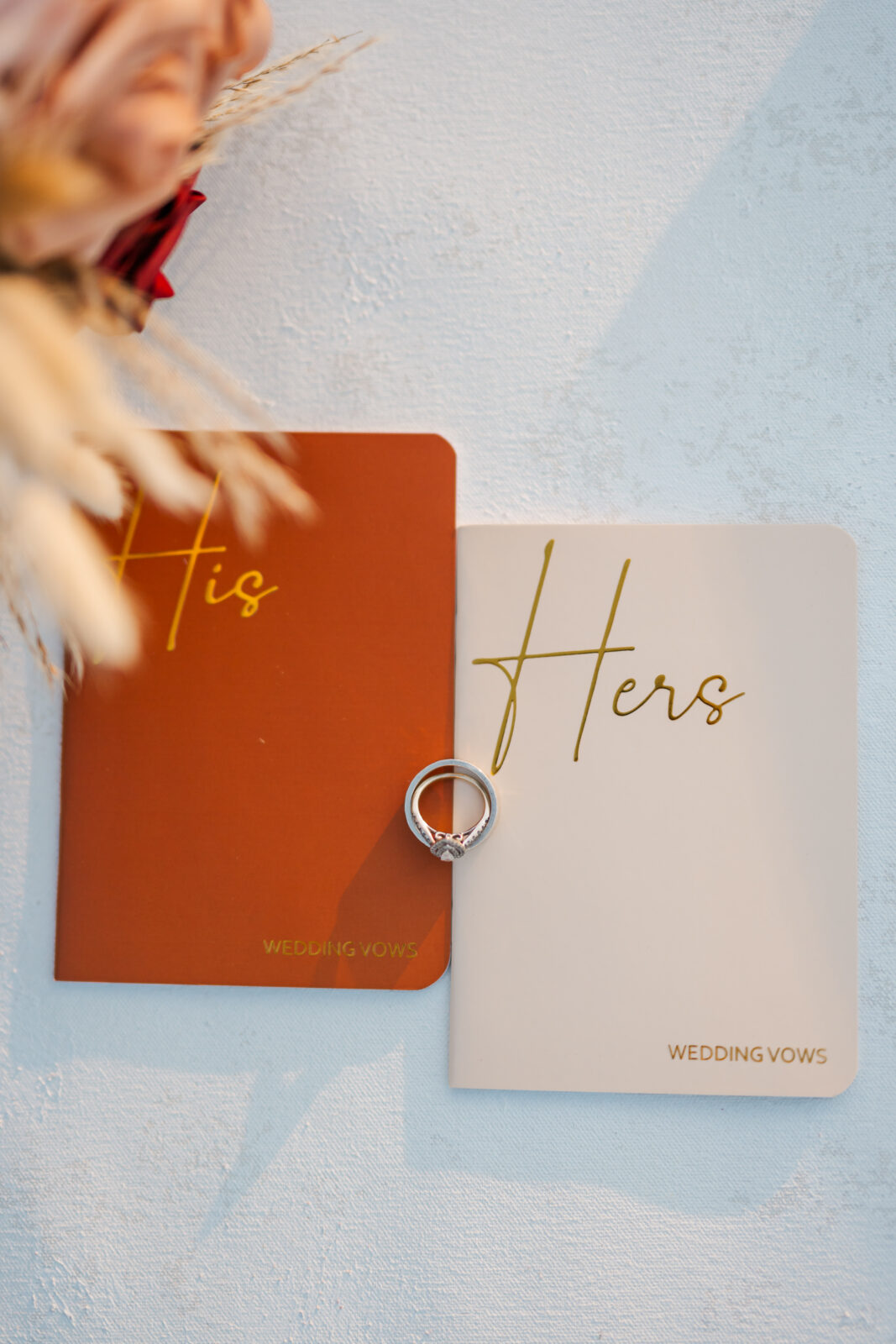 Flat lay of wedding vow books, rings, and flowers styled together for a Smoky Mountain sunrise elopement — elegant detail photography by a Gatlinburg photographer.
