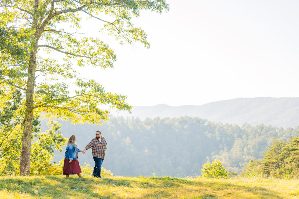 Couple walking in front of a sunset mountain backdrop — Smoky Mountain engagement photography.