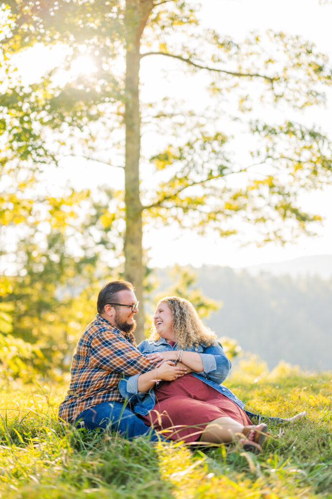 coupe embracing with golden glow an mountains behind them during their pigeon forge engagement session with a smoky mountain photographer