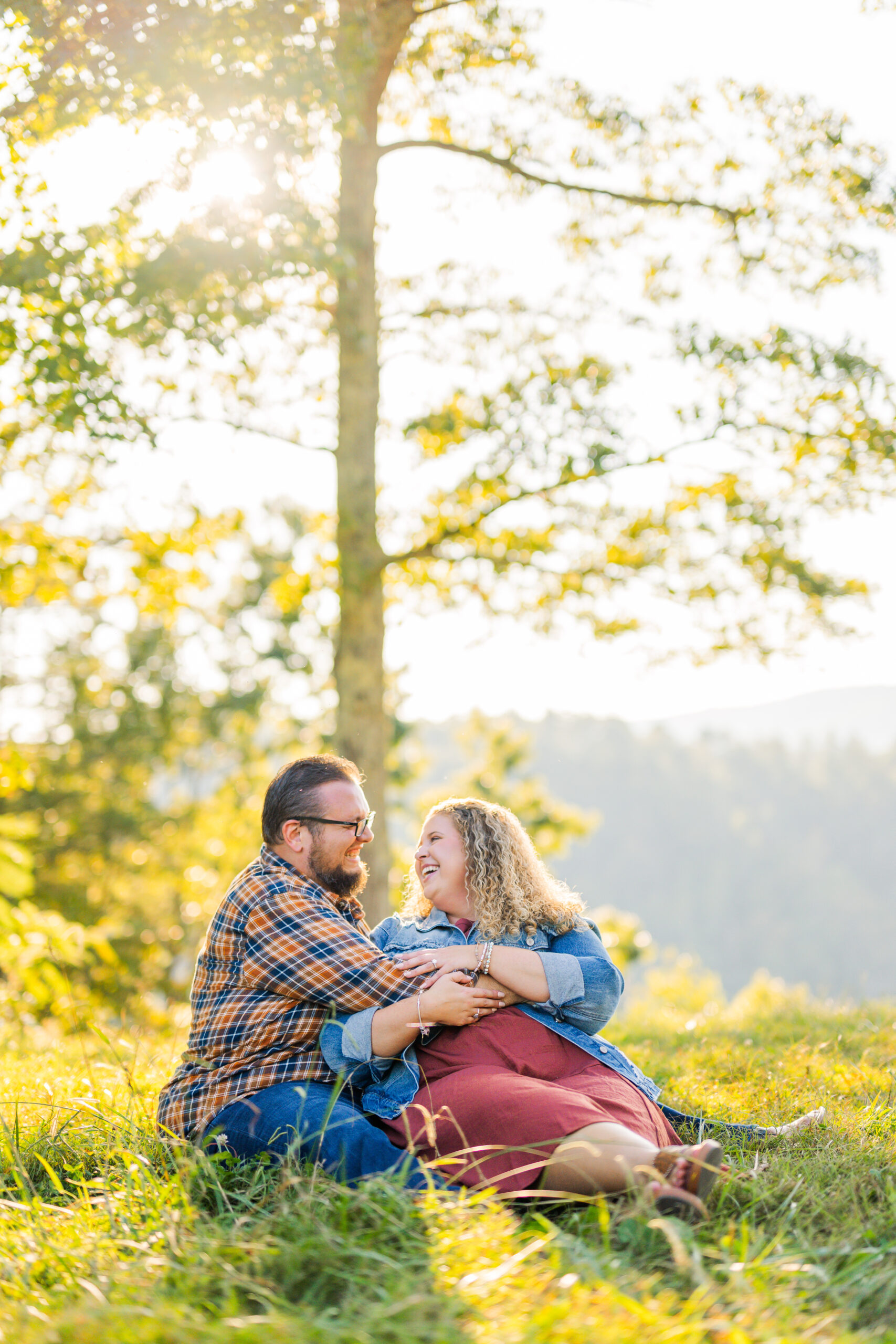Couple cuddling up in the great smoky mountains national park during a sunset engagement session with a gatlinburg photographer