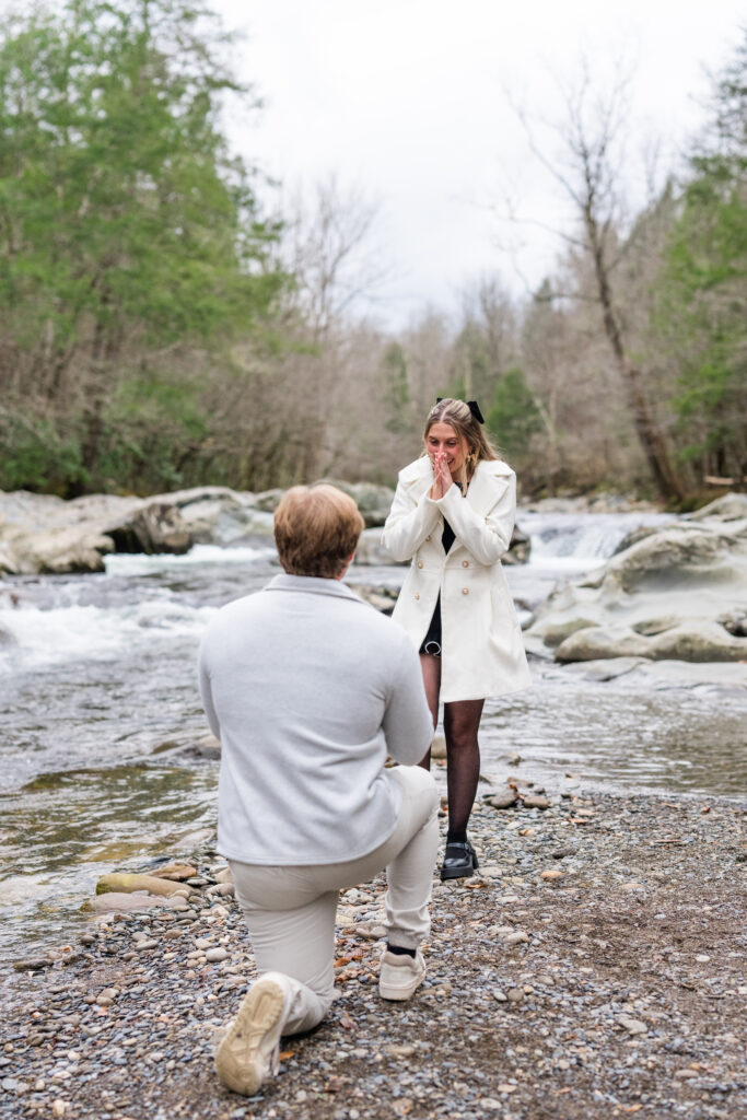 a man proposing to a woman in gatlinburg, tn by the little pigeon river in the great smoky mountains national park