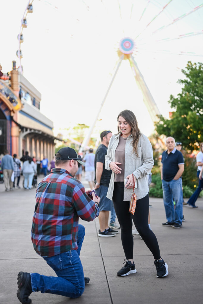 a man proposing to a woman in front of the sky wheel at the island in pigeon forge tennessee
